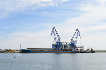 Obraz premium Crane and cargo ship in the Balchik bay in Bulgaria.