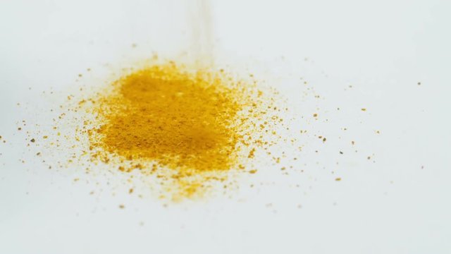Saffron falls down on white surface.
Slow motion footage of falling down orange powder.