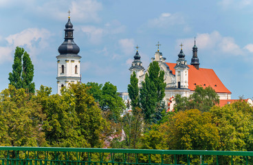 The black domes of the church hidden behind the trees shine under the rays of the summer sun