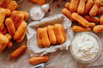 Homemade eclairs. Preparation of eclairs in the home kitchen. The process of cooking eclairs.Eclair a small, soft, log-shaped pastry filled with cream and typically topped with chocolate icing.