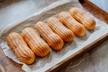 Homemade eclairs. Preparation of eclairs in the home kitchen. The process of cooking eclairs.Eclair a small, soft, log-shaped pastry filled with cream and typically topped with chocolate icing.