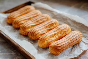 Homemade eclairs. Preparation of eclairs in the home kitchen. The process of cooking eclairs.Eclair a small, soft, log-shaped pastry filled with cream and typically topped with chocolate icing.