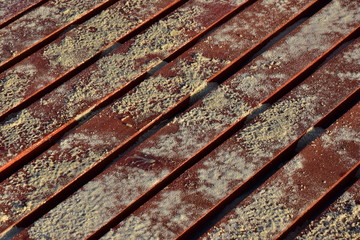 Background of sand on wooden red boards. Stairway of boards on a sandy beach