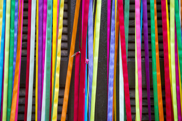 Colorful curtain of strips of decorative shiny carnival ribbon cover the entrance to a door in...