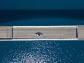 Vista aerea del ponte dell’isola di Pag, Croazia, strada. Scogliera a picco sul mare. Auto che...