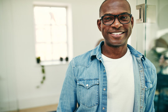 Smiling African businessman standing in a modern office