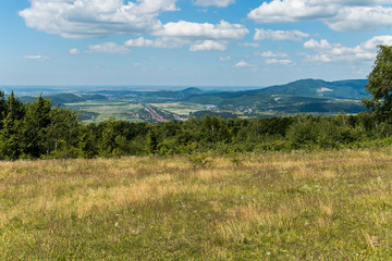 Beautiful view with field, mountains and trees. the sky with white, small clouds