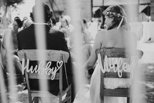 Braut und Br&auml;utigam auf St&uuml;hlen bei Outdoor Hochzeit