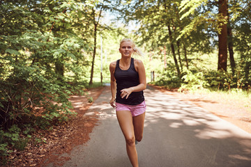 Fit young woman jogging alone through a forest