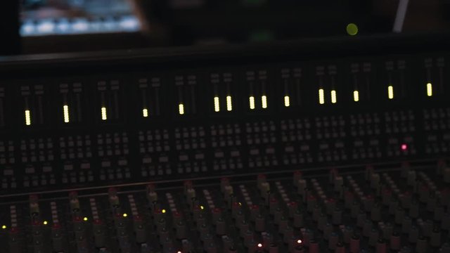 Horizontal slide across audio desk at recording studio
