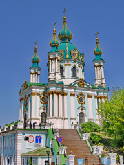 Fototapeta na wymiar in the cloudless blue sky, the golden green domes of the ancient church