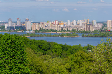 Panorama of multi-storey buildings on the shore of the Dnipro River under the blue sky. Kiev. Ukraine