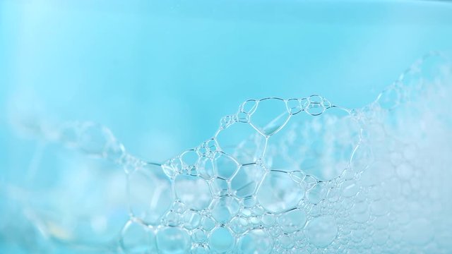 Foam. Soap foam popping bubbles background. Foam macro structure closeup. Washing concept. Slow motion 4K UHD video 3840x2160