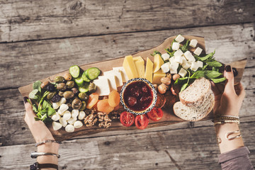Delicious breakfast on cutting board carried by a young woman