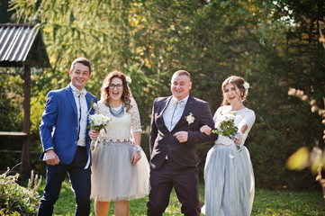 Groomsmen and bridesmaids having fun in the park next to gazebo.