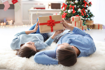 Young couple with Christmas gift at home