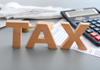 Word TAX and calculator on table, closeup