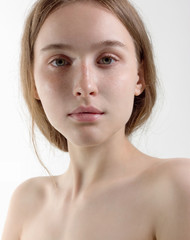 Naklejka premium Piękna delikatna dziewczyna blondynka z idealną skórą na białym tle. Naturalne piękno, makijaż dzienny. Piękno, czystość. Procedury kosmetologiczne i spa.