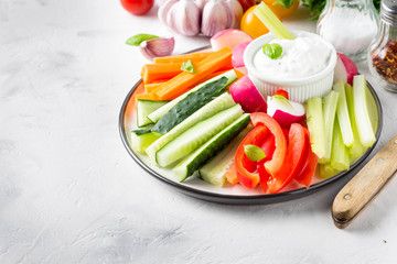 Vegetable sticks of cucumber, pepper, carrots, celery and radishes with white sauce of sour cream, yogurt, herbs.