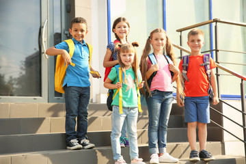 Cute little children with backpacks outdoors. Elementary school