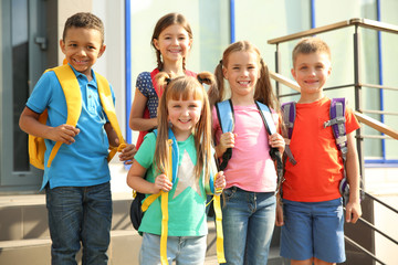 Cute little children with backpacks outdoors. Elementary school