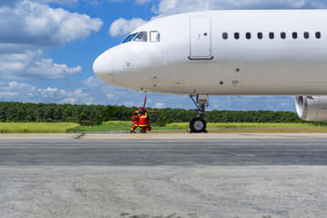 Safety for airport runway staff and white aircraft