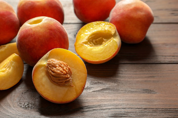Fototapeta na wymiar Fresh sweet peaches on wooden table, closeup