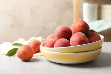 Plates with fresh sweet peaches on table