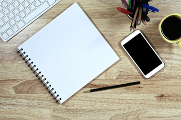 Blank white Paper and smart phone with  black screen and the cup of coffee and office supply for working business communication concept.