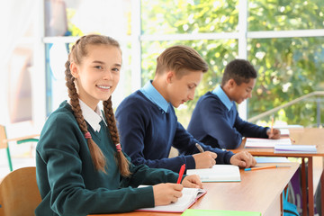 Teenage students in classroom. Stylish school uniform - obrazy, fototapety, plakaty
