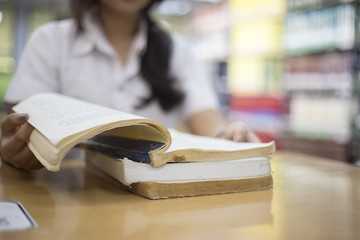 Female students are reading books in the library.