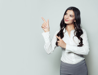 Happy business woman pointing her finger to empty copy space for advertising marketing or product...