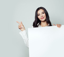 Naklejka premium Smiling business lady with white empty board background with copy space for advertising marketing or product placement. Successful business woman portrait