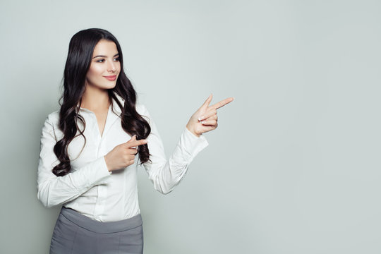 Successful businesswoman pointing her finger to empty copy space for  advertising marketing or product placement. Business, seo or education concept