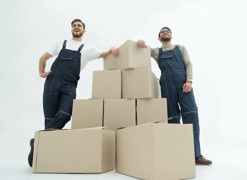 Young Men Carrying A Box To The Pile Of Boxes.