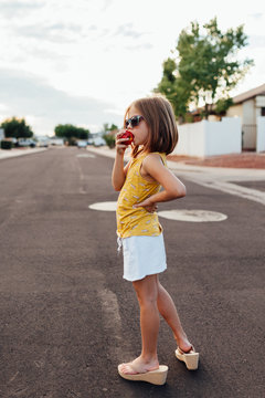 Girl Eating Apple in Street