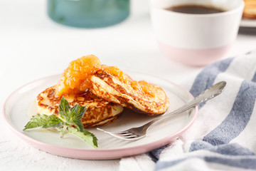 Cottage cheese pancakes, syrniki, curd fritters. Breakfast with coffee, cheesecake and apricot jam. Flatlay. Top view. copyspace