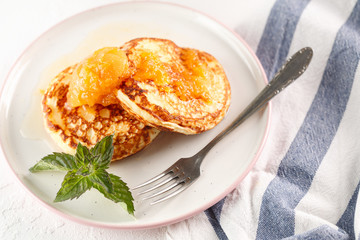 Cottage cheese pancakes, syrniki, curd fritters. Breakfast on white background cheesecake and apricot jam. Top view. copyspace