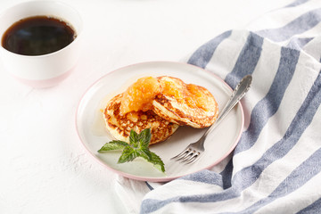 Cottage cheese pancakes, syrniki, curd fritters. Breakfast with coffee, cheesecake and apricot jam. copyspace