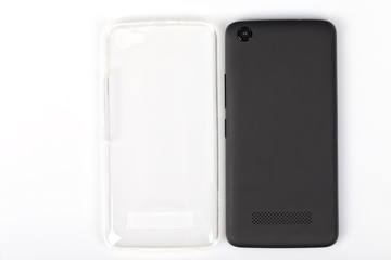 A black smartphone next to its protective rubber back cover isolated on white