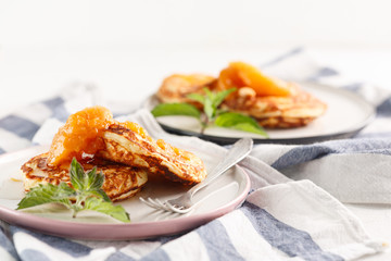 Cottage cheese pancakes, syrniki, curd fritters. Breakfast on white background cheesecake and apricot jam.