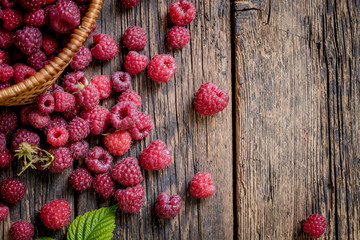 Obraz na płótnie Canvas Ripe, freshly picked raspberries, on rustic wooden old table surface. Flat lay.