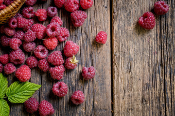Ripe, freshly picked raspberries, on rustic wooden old table surface. Flat lay.