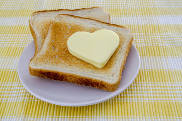 dos tostadas de pan con un corazón de mantequilla 