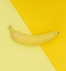 Creative view of a banana on a background of similar colors. Yellow background.