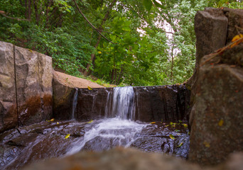 Fototapeta na wymiar Waterfall from the river in the park