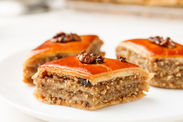 Oriental sweets with walnut in a white plate on a wooden table