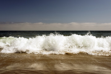 Waves breaking in the Pacific ocean in Malibu, Los Angeles, California in summer time