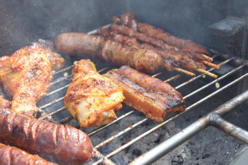 roasted chicken, sausage and bacon on the grill