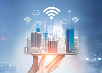 Man holding city hologram in city, wifi network